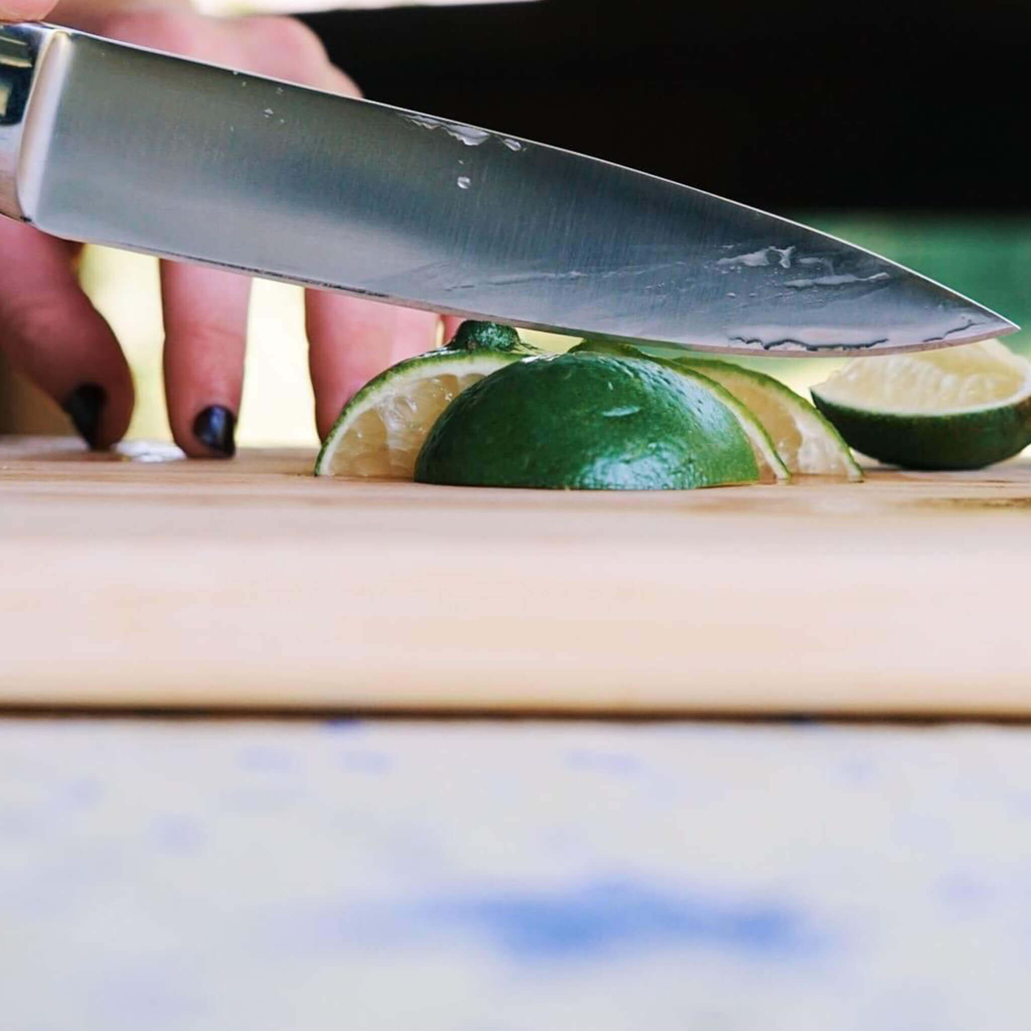 Forged Fine-Edge Steak Knife Cutting a Lime